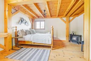 a bedroom with a bed and a wood stove at The Vista - Magnificent waterfront beach & hot tub in Val des Monts