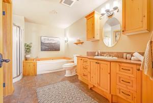 a bathroom with a tub and a toilet and a sink at The Vista - Magnificent waterfront beach & hot tub in Val des Monts +82 photos