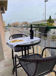 einen Tisch mit einer Flasche Wein auf dem Balkon in der Unterkunft Casa Giada 1.0 in Marsala