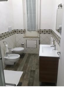 ein Badezimmer mit zwei Waschbecken, einem WC und einem Spiegel in der Unterkunft Casa Giada 1.0 in Marsala