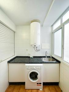 een keuken met een wasmachine en een wastafel bij Piso en el centro de Vigo 2 dormitorios Brasil in Vigo