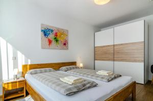 ユーバーリンゲンにあるApartment Alexのベッドルーム1室(ベッド2台付)が備わります。壁には絵画が飾られています。