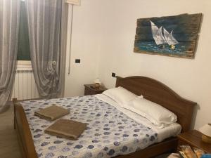 1 cama con 2 toallas en un dormitorio en GUEST HOUSE BERZEFI, en Bergeggi