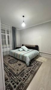 1 dormitorio con cama y alfombra en el suelo en Avocado en Bishkek