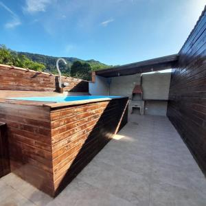 an outdoor swimming pool with a wooden wall at Chalé Ubatuba in Ubatuba +12 photos