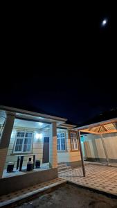 a home with a lit up front yard at night at Avocado in Bishkek