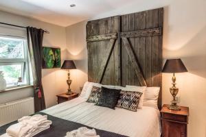 1 dormitorio con 1 cama grande y cabecero de madera en Luxury Lakefront villa, infinity hot tub and sauna, en Grímsnes og Grafningshreppur