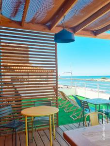 a patio with tables and chairs and the beach at Mon P'tit Hôtel in Le Grau-dʼAgde