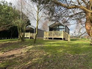 a house with a large yard with trees and grass at Pods 1 and 2 Willow Bank in Market Rasen