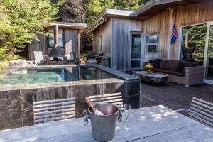 eine Terrasse mit einem Tisch und einem Pool in der Unterkunft Luxury Lakefront villa, infinity hot tub and sauna in Grímsnes og Grafningshreppur