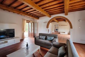 a living room with a couch and a tv at La Siepe - I Borghi Della Selvaccia in Cennina