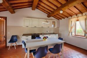 a kitchen with a table and blue chairs at La Siepe - I Borghi Della Selvaccia in Cennina