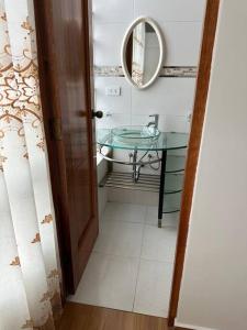 a bathroom with a glass sink and a mirror at Departamento Familiar Alado del aeropuerto in Cusco