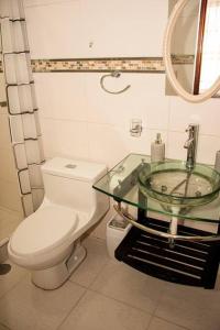een badkamer met een toilet en een glazen wastafel bij Departamento Familiar Alado del aeropuerto in Cuzco