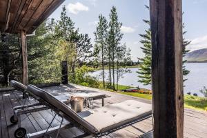 bañera de hidromasaje en una terraza con vistas al lago en Luxury Lakefront villa, infinity hot tub and sauna, en Grímsnes og Grafningshreppur