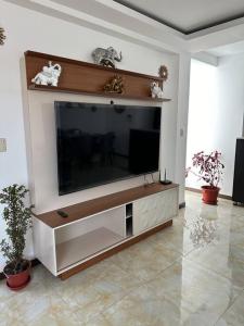 una sala de estar con un gran centro de entretenimiento con TV en Departamento Familiar Alado del aeropuerto, en Cusco