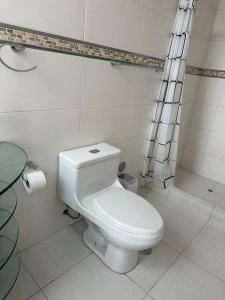 biała łazienka z toaletą i prysznicem w obiekcie Departamento Familiar Alado del aeropuerto w Cuzco