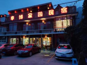 two cars parked in a parking lot in front of a building at Tianjin Huangyaguan Great Wall Home Hotel in Jixian