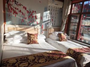 a bedroom with two beds and a window at Tianjin Huangyaguan Great Wall Home Hotel in Jizhou
