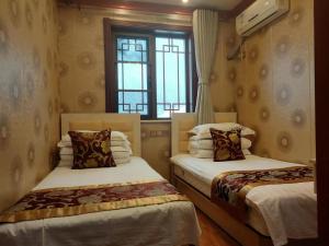 2 Betten in einem Zimmer mit Fenster in der Unterkunft Tianjin Huangyaguan Great Wall Home Hotel in Jixian