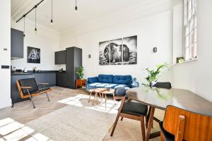 un soggiorno con divano blu e tavolo di GuestReady - Luxury haven in Palmers Green a Palmers Green