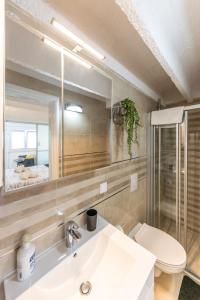 a bathroom with a sink and a toilet and a mirror at Val Apartments in Dubrovnik