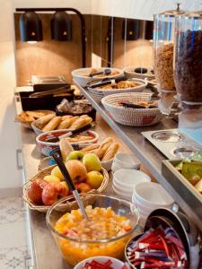 a buffet line with bowls of fruit and other foods at Hotel Les Palmiers En Camargue in Saintes-Maries-de-la-Mer