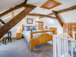 a bedroom with a wooden bed in a room with exposed beams at 2 Bed in Ulverston 83453 in Great Urswick