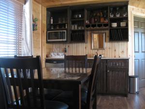 una cucina con tavolo, sedie e forno a microonde di Centre de Vacances 5 Étoiles Family Resort a Sacré-Coeur