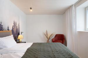sypialnia z łóżkiem i czerwonym krzesłem w obiekcie Ferienwohung Forestdreams w mieście Weilheim