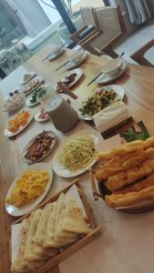 une table en bois avec des assiettes de nourriture dans l'établissement Tianjin Huangyaguan Great Wall Home Hotel, à Jixian