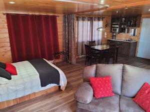 sypialnia z łóżkiem, kanapą i stołem w obiekcie Centre de Vacances 5 Étoiles Family Resort w mieście Sacré-Coeur-Saguenay