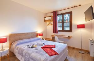 a bedroom with a bed with a red shirt on it at Cit'H&ocirc;tel Le National in Cluses