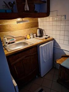 a small kitchen with a sink and a dishwasher at Szalupa Hostel Airport in Zakroczym