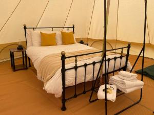 a bedroom with a bed in a tent at Dartmoor Halfway Campsite in Newton Abbot