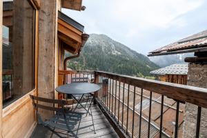 a table on a balcony with a view of a mountain at Chalet Alouette in Champagny-en-Vanoise