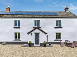 a white house with solar panels on the roof at 2 bed in Dartmoor National Park WAYTO in Ashbury