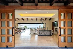 una puerta abierta a una sala de estar con mesa en Phenomenal Oceanview Villa in Puerto Los Cabos, en San José del Cabo