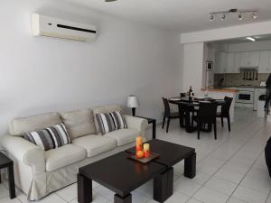 a living room with a couch and a table at Cyprus-2 bedrooms both ensuite pool patios wifi in Polis Chrysochous