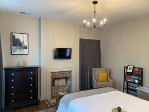 a bedroom with a bed and a tv and a fireplace at DERBY LUXE 3-story Historic 6 min from Churchill in Louisville