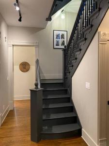 a hallway with a black staircase in a home at DERBY LUXE 3-story Historic 6 min from Churchill in Louisville
