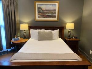 a bedroom with a large bed with two lamps on tables at DERBY LUXE 3-story Historic 6 min from Churchill in Louisville