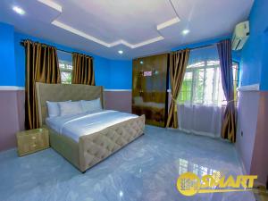 a bedroom with a bed in a blue room at IMSMART Luxury Homes in Uyo