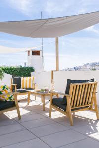 due sedie e un tavolo e un ombrellone su un tetto di Golden Stay - B&B Experience ad Albufeira