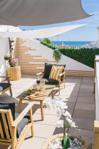 a patio with chairs and a table on a roof at Golden Stay - B&B Experience in Albufeira