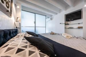 a bedroom with a large bed with a flat screen tv at Val Apartments in Dubrovnik