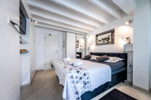 Val Apartments في دوبروفنيك: غرفة نوم بسرير في غرفة بجدران بيضاء