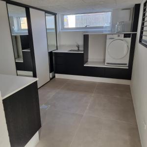 a bathroom with a sink and a washing machine at Poppel alle 2 b Hirtshals in Hirtshals