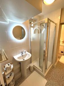 ein Bad mit einem Waschbecken und einer Dusche in der Unterkunft East Finchley N2 apartment close to Muswell Hill & Alexandra Palace with free parking on-site in London