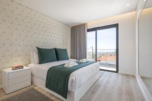 een slaapkamer met een bed en een groot raam bij Contemporary Residence C by Madeira Sun Travel in Funchal